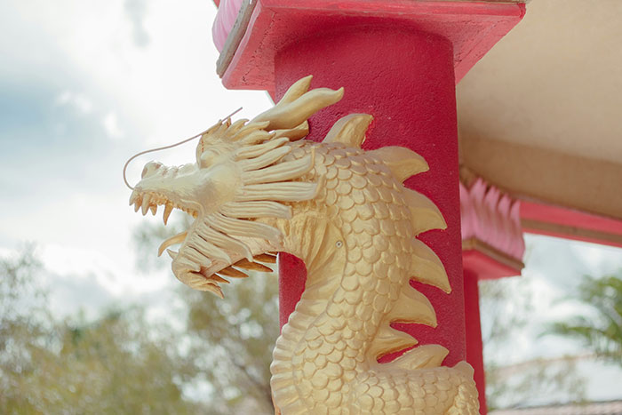 Golden dragon sculpture on a red pillar, showcasing extravagant decor that the super rich can buy.