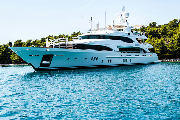 Luxurious yacht anchored in clear blue waters, a symbol of what the super rich can buy.