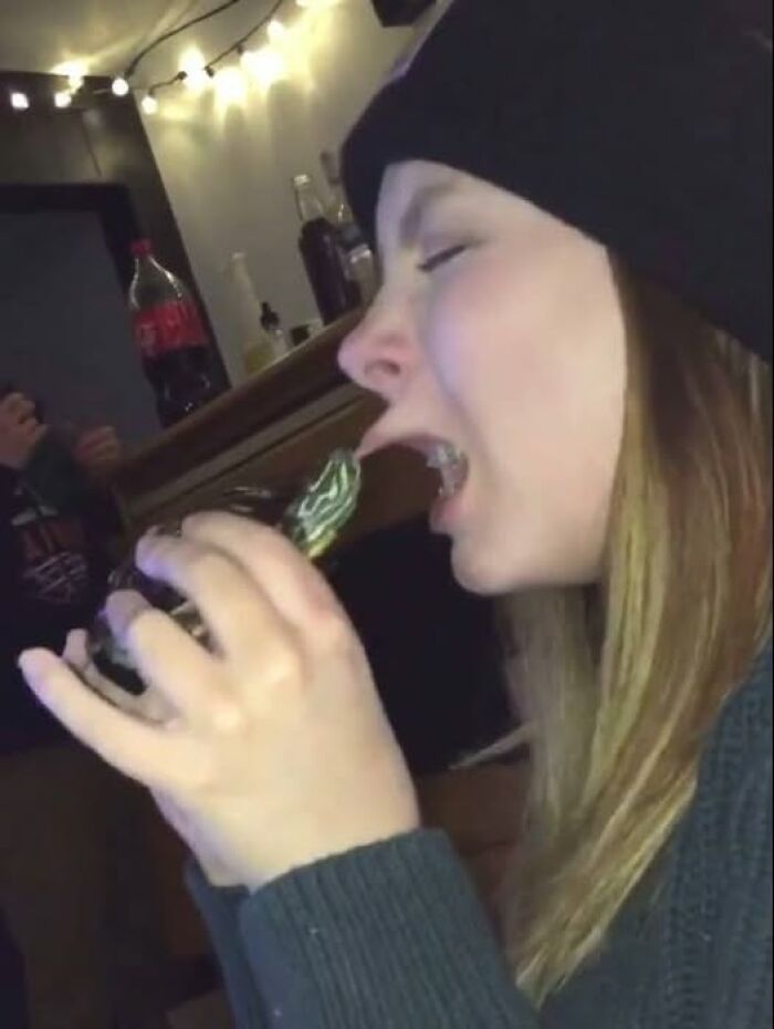 Young woman playfully pretending to eat a small turtle, creating a wholesome animal moment.