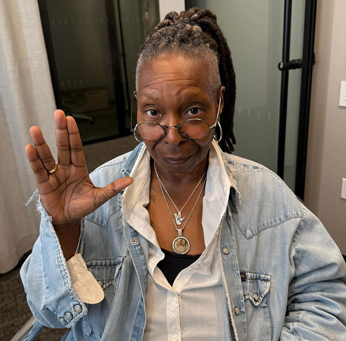 Whoopi Goldberg wearing glasses and denim shirt gestures in an office setting. Oscars boycott discussed in relation to presenters. Whoopi Goldberg wearing glasses and denim shirt gestures in an office setting. Oscars boycott discussed in relation to presenters.