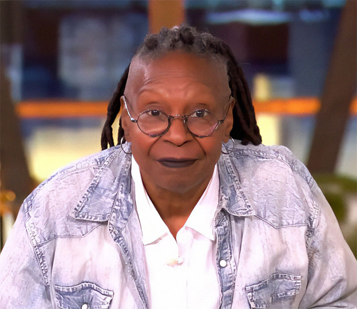 Presenter announced for Oscars, wearing a denim jacket and glasses against a blurred background. Presenter announced for Oscars, wearing a denim jacket and glasses against a blurred background.