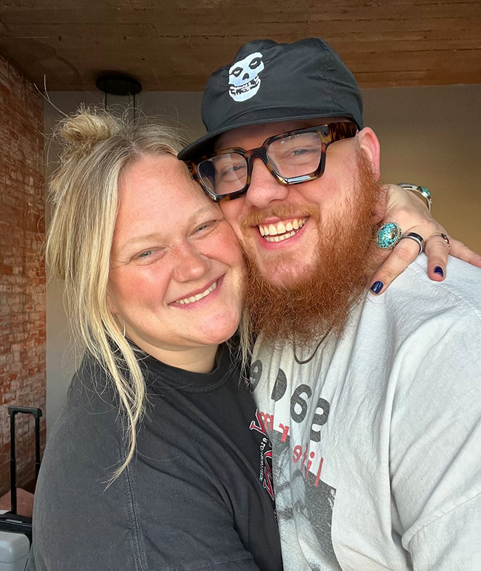 Couple smiling warmly in casual outfits, highlighting the viral shower clip trend.