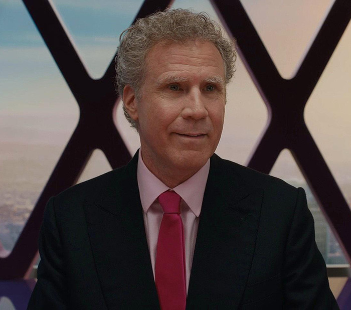 Will Ferrell in suit and pink tie smiling from the movie "Barbie.