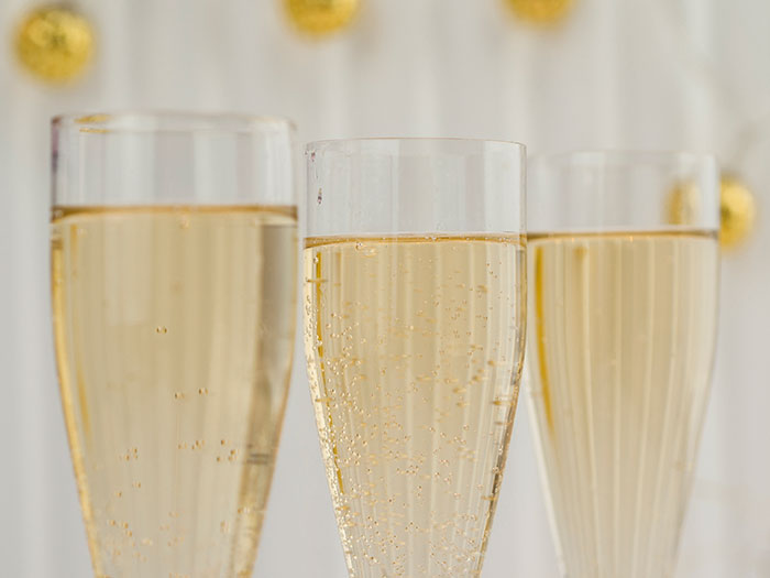 Three fancy glasses filled with champagne, elegantly arranged for a celebration.