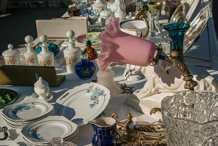 Estate sale collection featuring fancy glasses and decorative items displayed on a table.