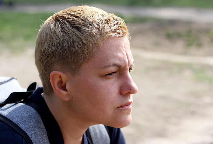 A person with short hair looking thoughtful outdoors, capturing assumptions about appearance and identity. A person with short hair looking thoughtful outdoors, capturing assumptions about appearance and identity.