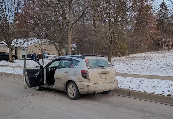 Auto sucio con puertas abiertas en una calle residencial con nieve, representando a hombres prepotentes.