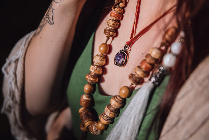 Close-up of a woman wearing a necklace with wooden beads, perfect for a simple Valentine's gift.