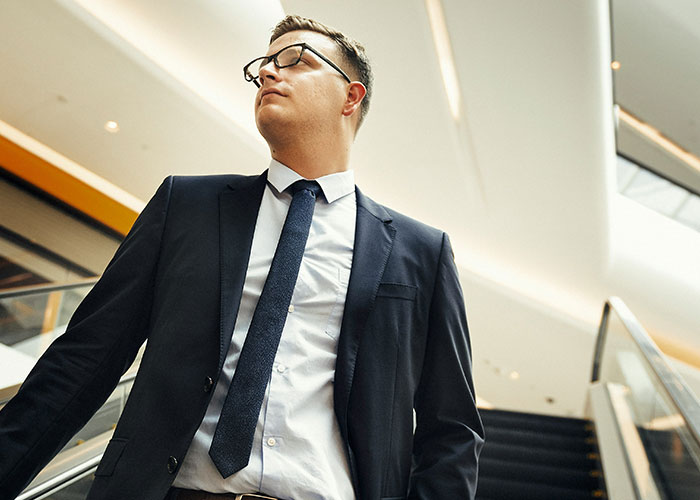 Man in a suit on escalator, symbolizing toxic workplace and staff quitting.