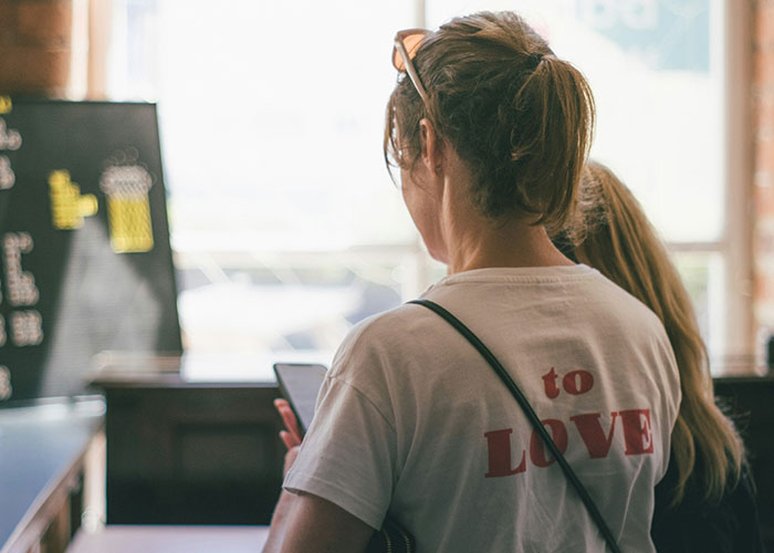 People standing in a workplace environment, focused on their phones, hinting at a possible toxic workplace atmosphere.