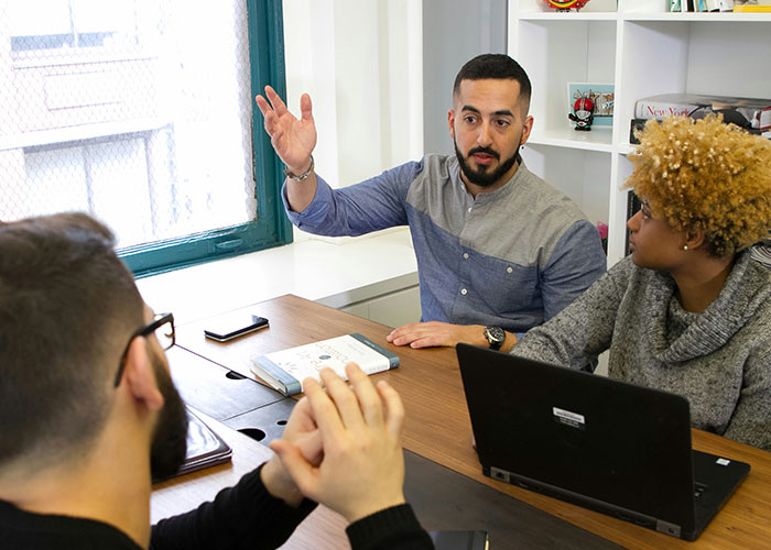 Team discussing strategies in a meeting, highlighting workplace dynamics in a potentially toxic environment.