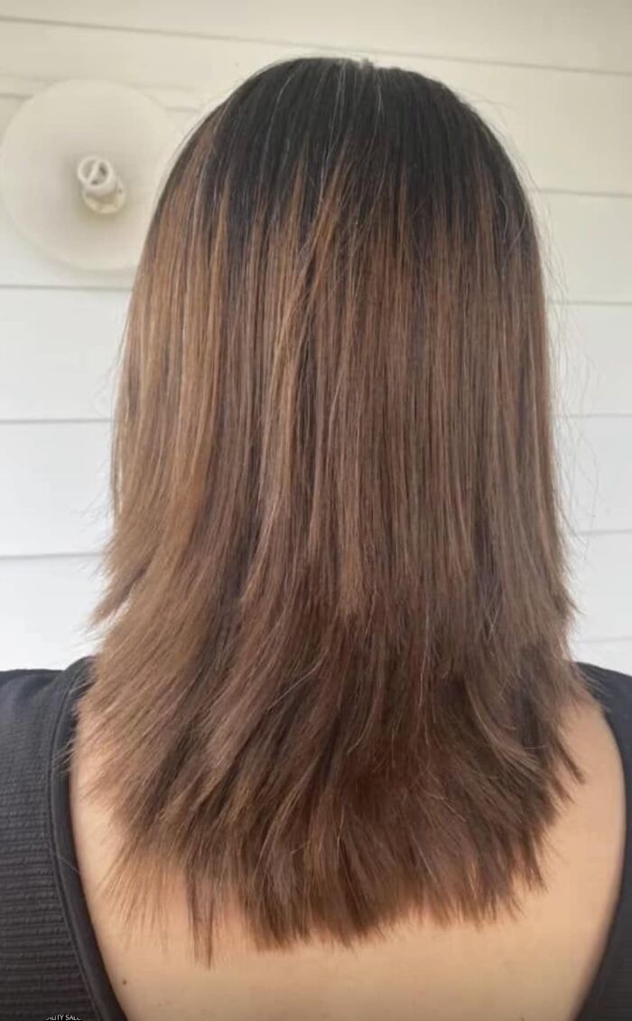 Uneven haircut showing different lengths, illustrating a hair fail with dark roots and lighter ends.