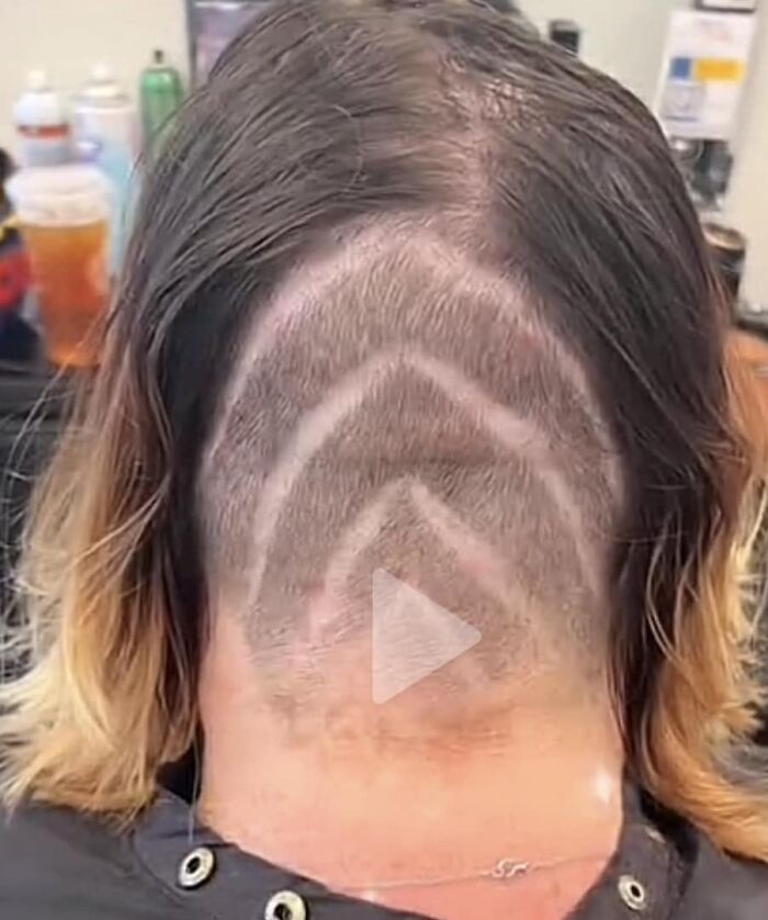 Hair fail with uneven shaved design on back of head in a salon.