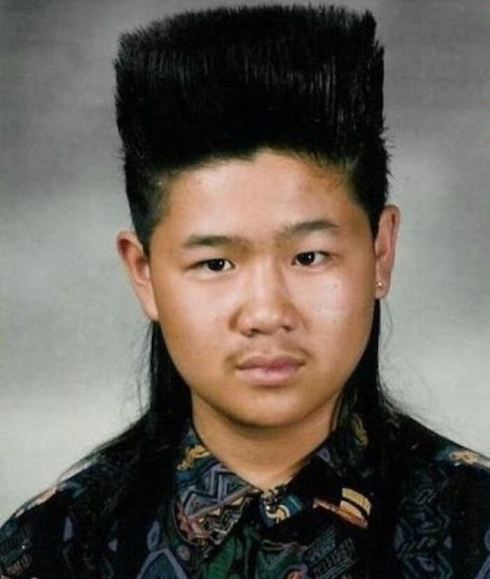 Man with a high flat top hairstyle, an iconic 1980s and 1990s hair trend disaster, wearing a patterned shirt.