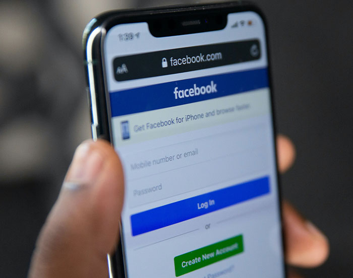 A smartphone displaying the Facebook login page, highlighting attention-seeking behavior on social media.