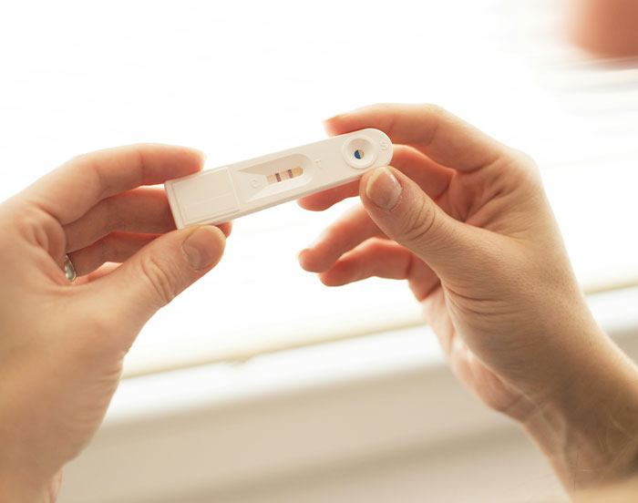 Hands holding a positive pregnancy test, symbolizing attention-seeking behavior.