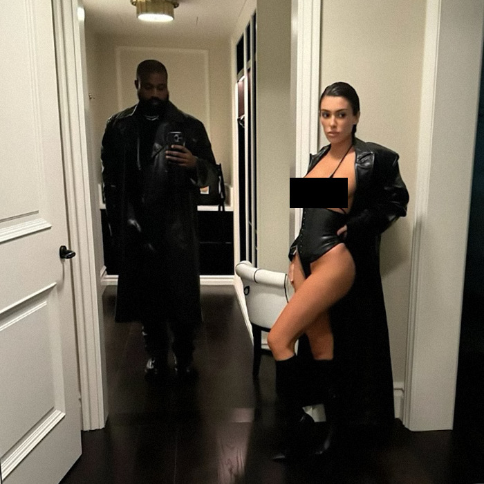 Man in black coat takes mirror selfie with woman in revealing outfit, fits Kanye West AI meme keyword theme. Man in black coat takes mirror selfie with woman in revealing outfit, fits Kanye West AI meme keyword theme.