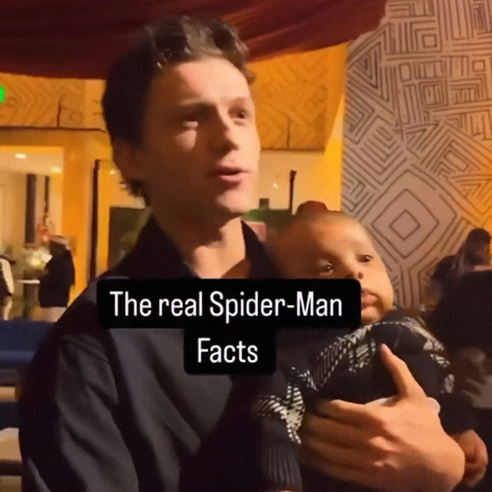 Man holding a baby at a family gathering, with text overlay about Spider-Man facts. Man holding a baby at a family gathering, with text overlay about Spider-Man facts.