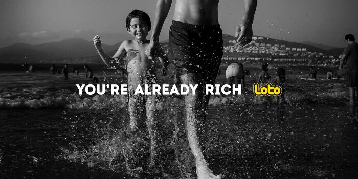 Boy and man happily running through waves, ad campaign emphasizes, "You're Already Rich.