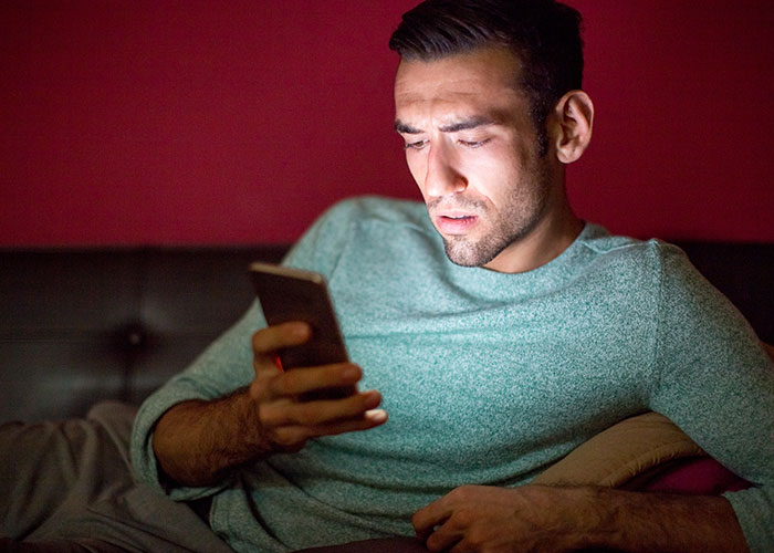 Man looking shocked at phone screen, proposal plans disrupted.