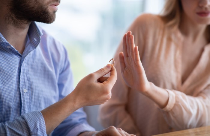 Man offering engagement ring to woman who declines, highlighting family expectations discussion.