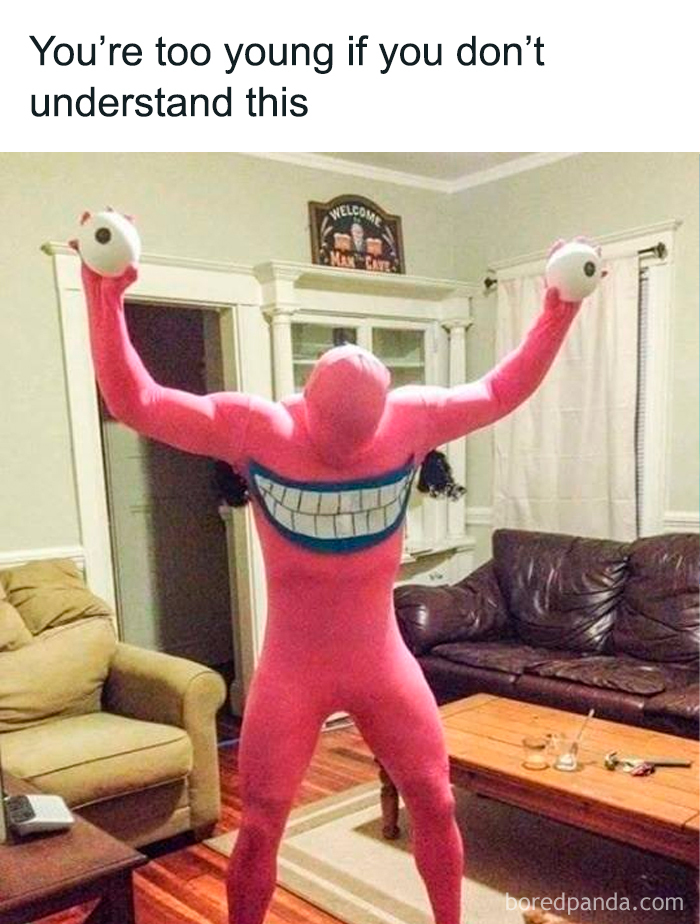 Person in a pink costume resembling an old cartoon character, holding ping-pong balls in a living room.