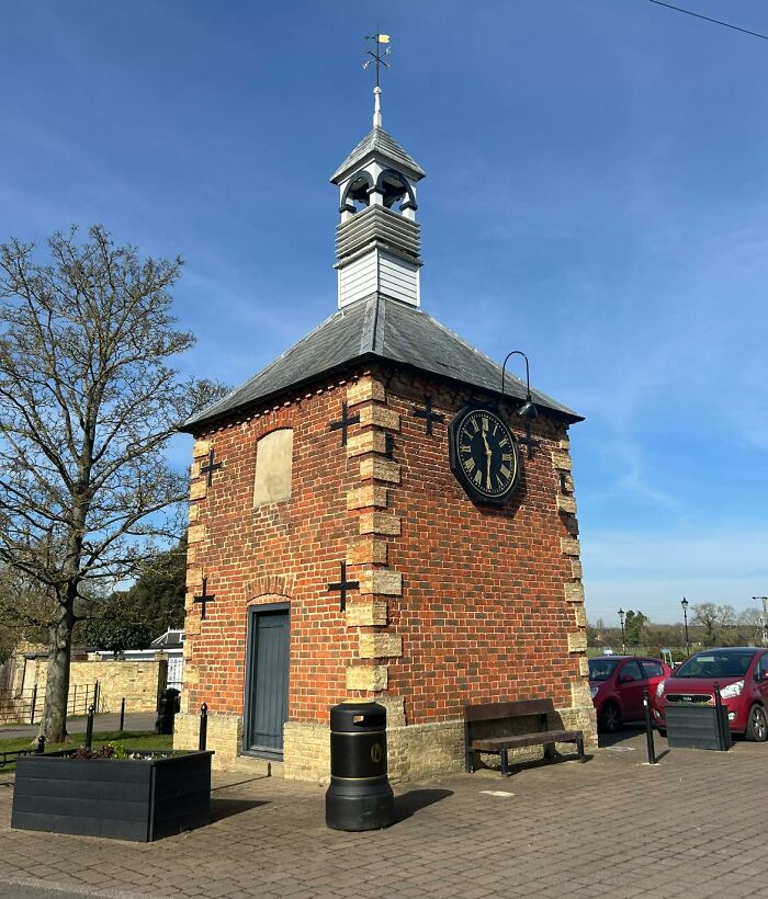 Quaint British clock tower with brick exterior, blue sky, and vintage charm.
