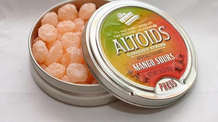 Open tin of discontinued Altoids Mango Sours, showcasing the nostalgic candy.