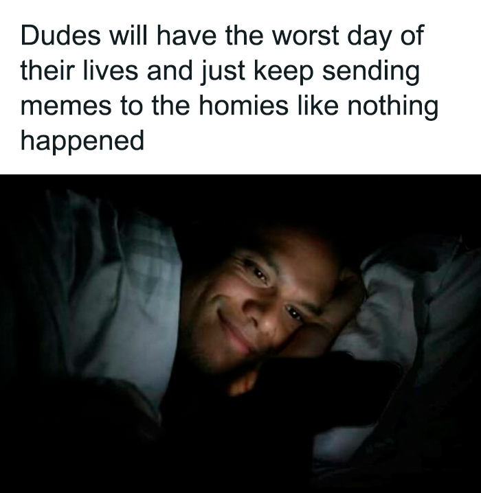 Man lying in bed, smiling at his phone, representing funny and relatable memes for men.
