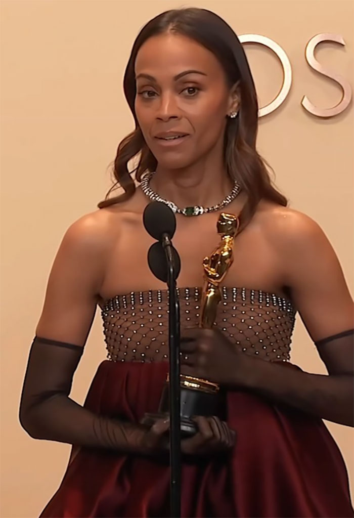 Zoe Salda&ntilde;a holding an award, addressing controversy at Oscars event.