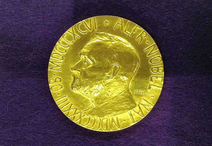 A gold Nobel medal on a dark background, showcasing a favorite place to hide valuable things at home.