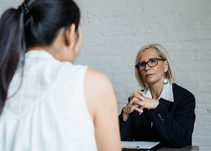 Two women in a serious discussion in an office setting, highlighting workplace red flags.