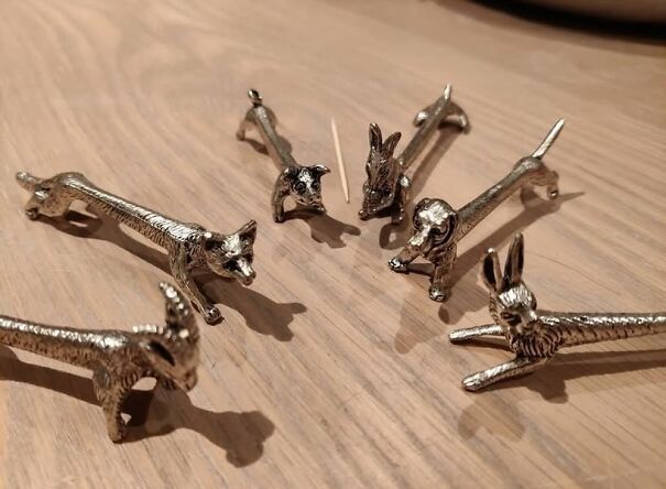 Silver animal-shaped salt and pepper shakers arranged on a wooden table, a unique thrifting find.