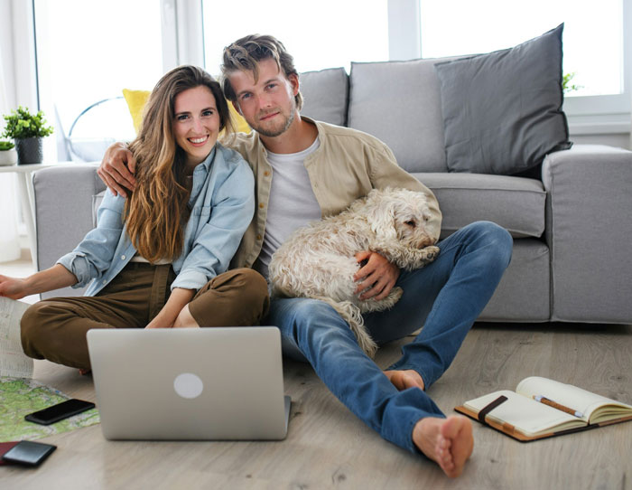 Man with partner and dog, sitting on floor, expressing emotions about in-laws and wedding cancellation. Man with partner and dog, sitting on floor, expressing emotions about in-laws and wedding cancellation.