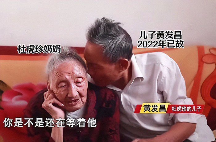 Elderly Chinese woman sitting with her son, symbolizing life and waiting.
