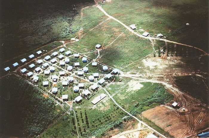 Aerial view of a historical settlement, showcasing organized layout amidst surrounding fields.