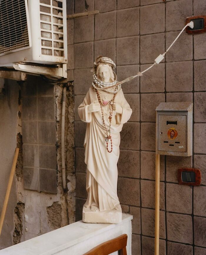 Statue in a street scene entwined with cables, capturing an unexpected and perfectly timed moment.
