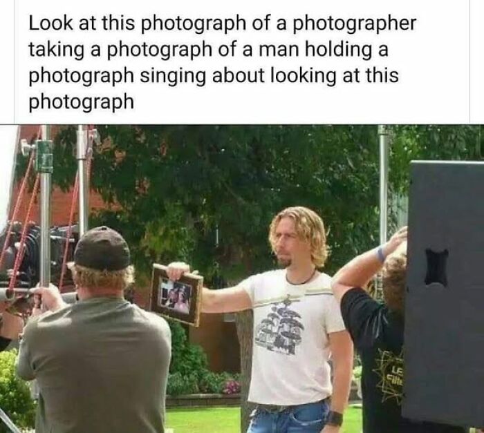 Photographer capturing man holding photo, creating a literal meme moment.
