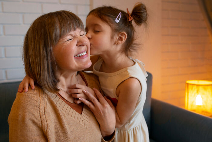 Child kissing woman on the cheek, illustrating a normal affectionate moment at home.