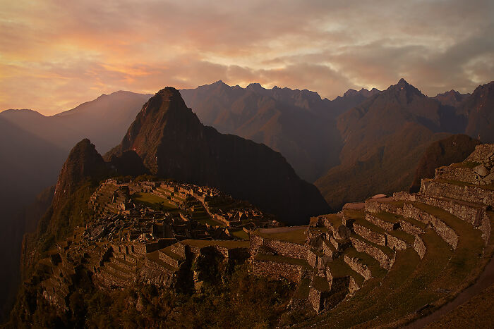 Machu Picchu under a dramatic sunset, showcasing culture and tradition in breathtaking detail.