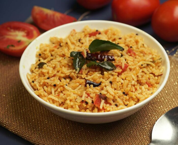 Bowl of spicy rice garnished with herbs and tomatoes, showcasing a lifetime supply winner's favorite dish.