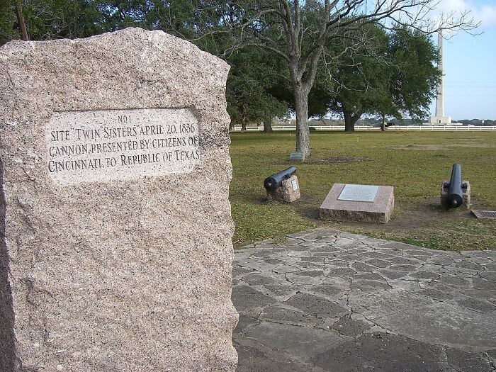 Memorial stone for the lost treasure Twin Sisters cannons, located in a historical park setting.
