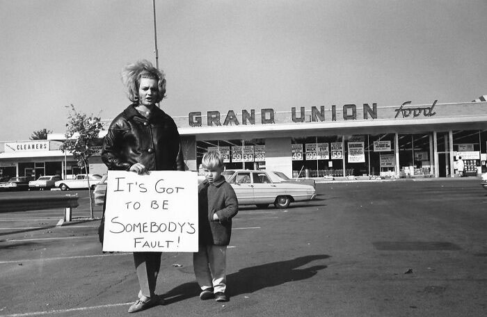 Woman and child in front of Grand Union store with a protest sign, depicting a forgotten corner of history.