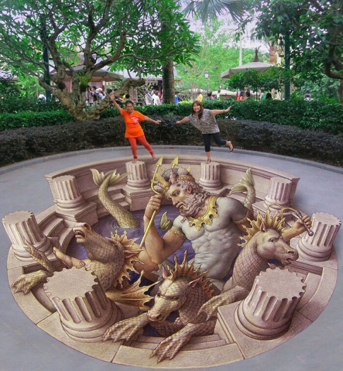 Two people interacting with 3D street art of a mythical scene featuring a trident-wielding figure and sea creatures.