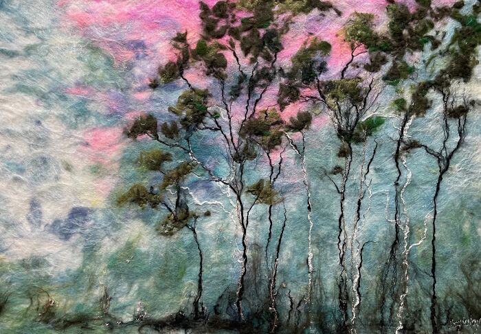 Fiber art scenery with trees against a pink and blue sky, created by Moy Mackay.