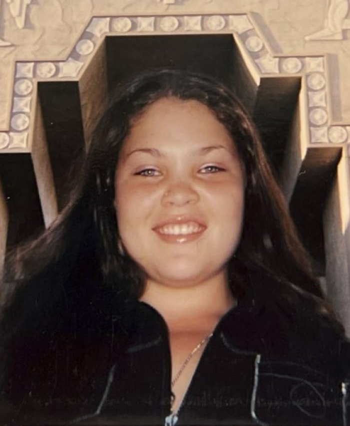 Smiling woman outdoors, standing in front of a decorative archway, symbolizing celebrity culture in Hollywood.