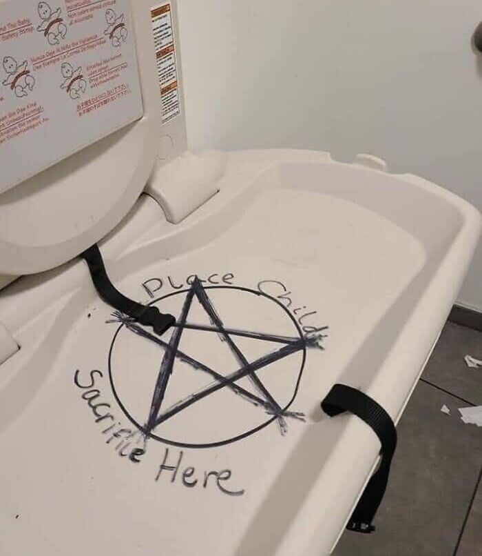 Funny random meme showing a changing table with a drawn pentagram and humorous text about child placement.