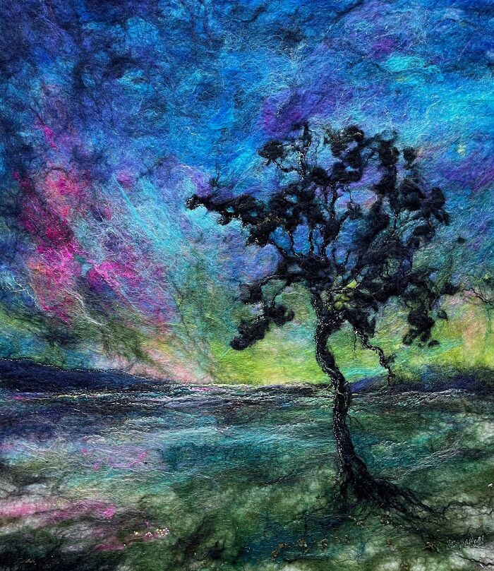 Fiber art landscape depicting a tree against a vibrant sky.