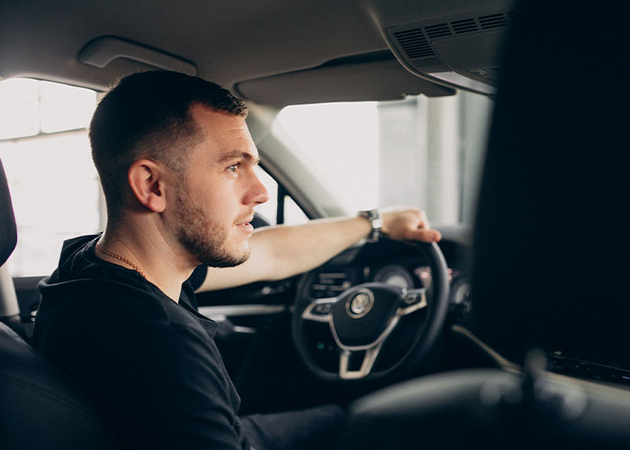 Man driving a car, looking focused, representing amazing dad stories.