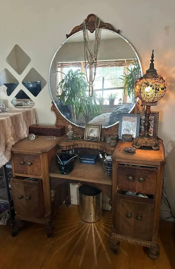 Antique wooden vanity with ornate mirror and vintage lamp, a unique thrift store find.